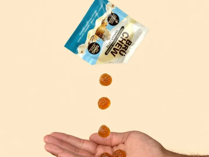 BrüChew Vanilla Latte chews dropping from the pack into a hand